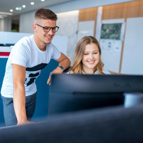 Zwei Studierende vor einem Monitor