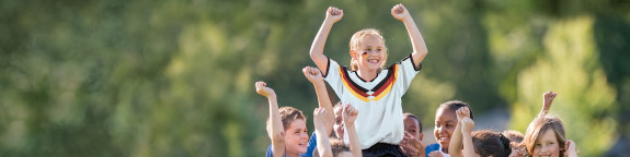 Kinder mit Fußballtrikots die jubeln