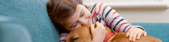 Mädchen schmust mit einem Hund