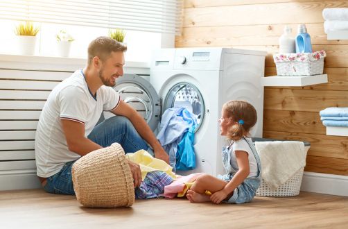 Mann und Mädchen vor Waschmaschine