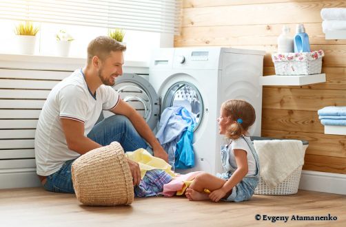 Mann und Mädchen vor Waschmaschine
