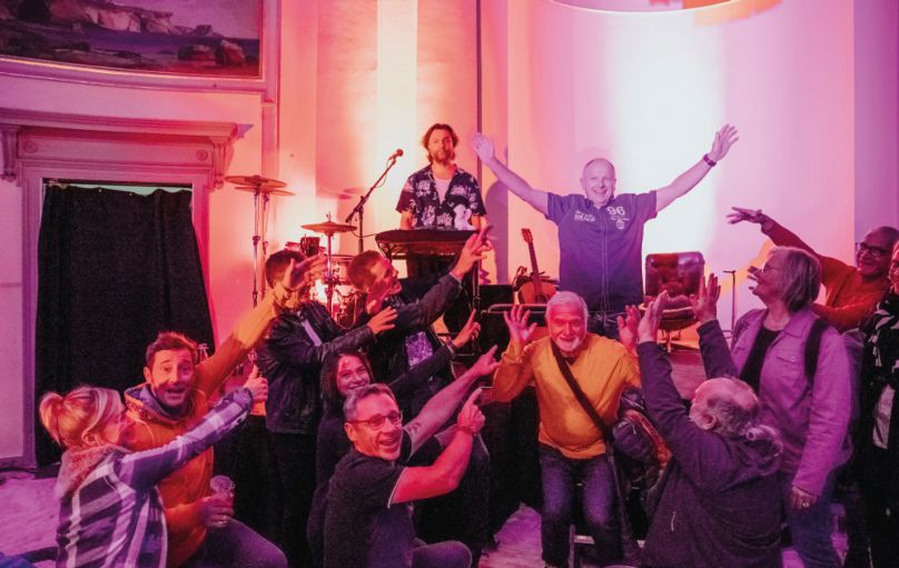 Jürgen Brenk und seine Begleiter*innen gemeinsam mit dem Musiker Kris Felix Bauer im Karlsruher Vierordtbad