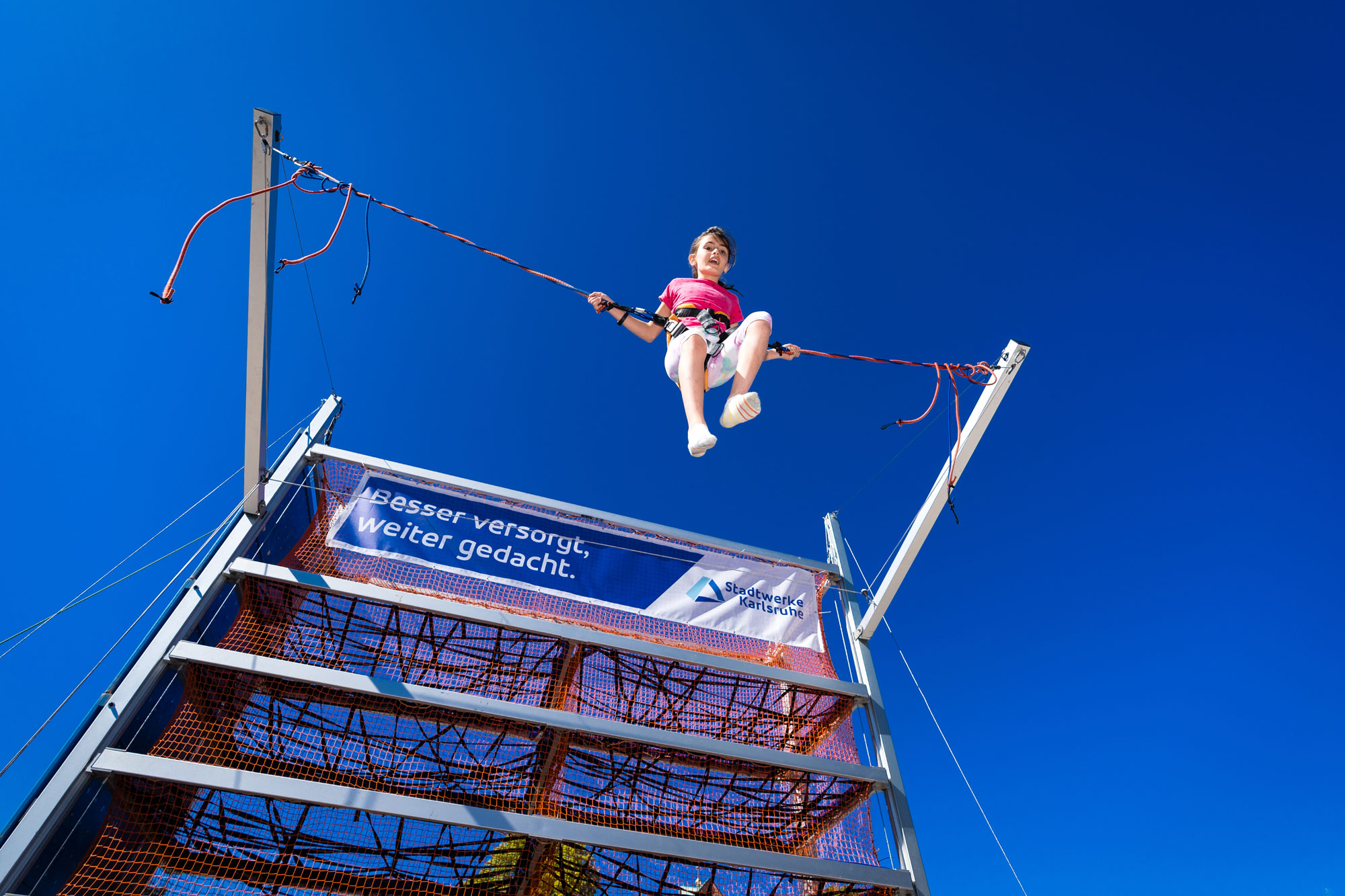 Mädchen springt gesichert auf einem Trampolin