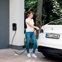 Frau lädt Elektroauto