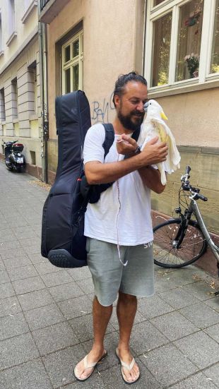 Person mit Kakadu auf dem Arm