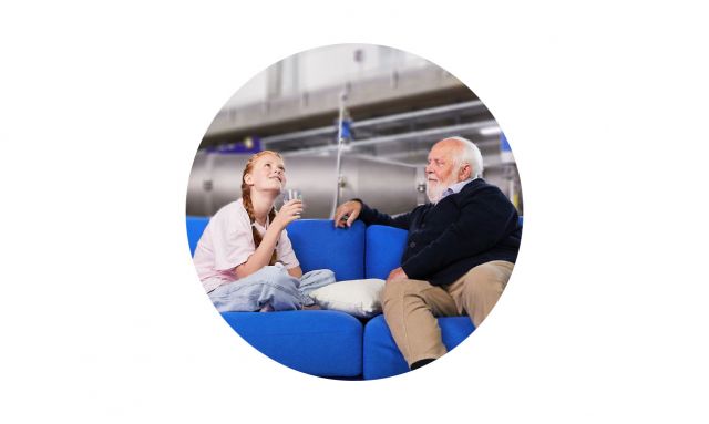 Bild Mann und Enkeltochter auf blauem Sofa in Fabrikhalle