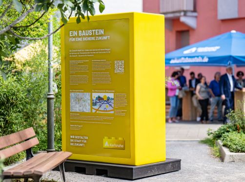 Das Bild zeigt einen der Bausteine, wie sie in Zukunft im ganzen Stadtgebiet zu finden sein werden. Zu sehen ist hier die Rückseite des gelben Bausteins, der für die Stadt Karlsruhe steht. 