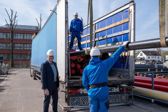 Stadtwerke-Geschäftsführungsvorsitzender Michael Homann (ganz links) beim Verladen der Fernwärmerohre