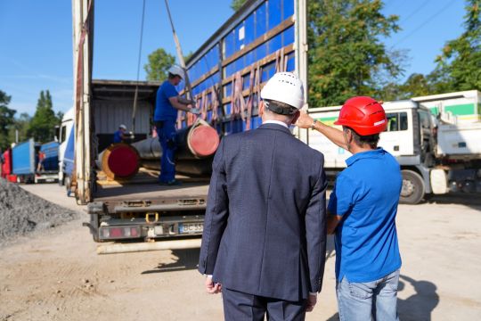 Stadtwerke-Geschäftsführungsvorsitzender Michael Homann (ganz links) beim Verladen der Fernwärmerohre