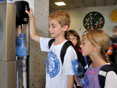 Kinder zapfen frisches Trinkwasser für die Pause.