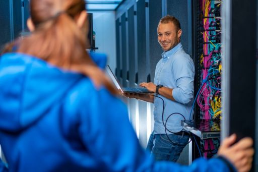 Techniker mit Computer an einem Serverschrank